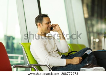 handsome mid age man talking on cell phone at airport