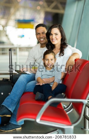 happy young family waiting for flight at airport