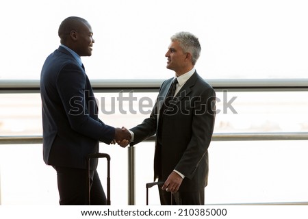 two professional businessmen hand shaking at airport