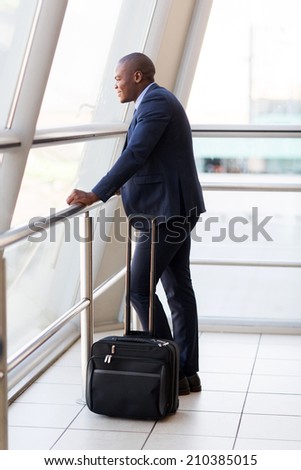 formal young african businessman with luggage at airport