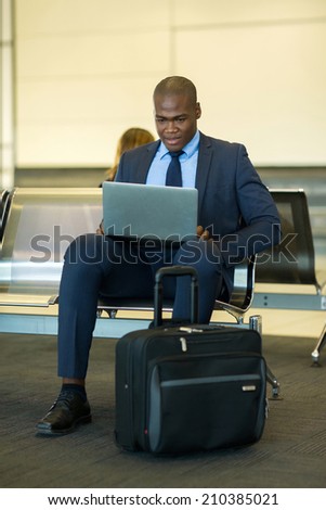 smart african businessman using tablet computer at airport