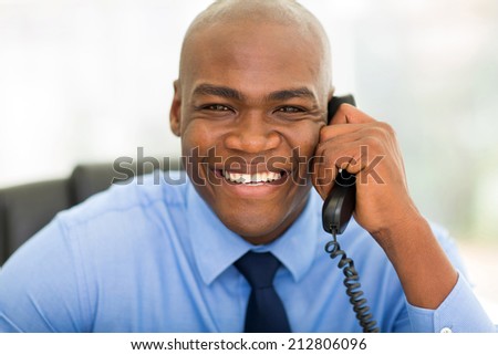 happy african businessman using landline phone