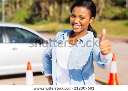 happy young african girl standing in driving school giving thumb up