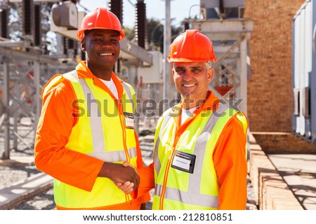 portrait of technical co-workers hand shaking in power plant