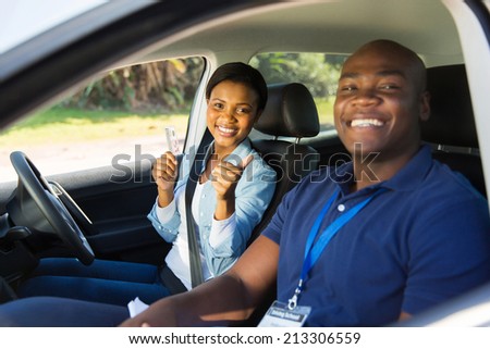 african woman has passed her driving test, holding driver\'s license