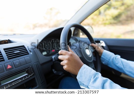 close up of woman\'s hands holding steering wheel