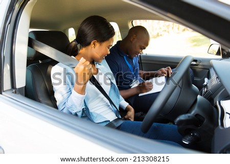 young african girl putting on seatbelt during a driving test