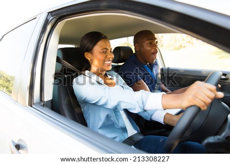 scared african girl taking driving lessons for the first time