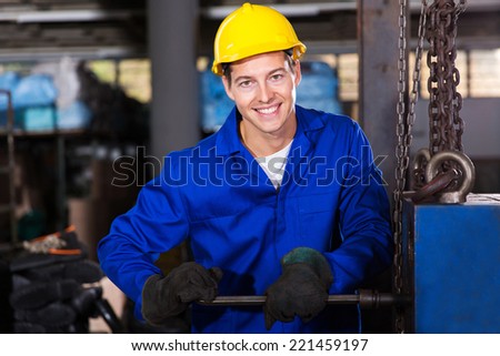 happy repairman fixing machine inside the factory