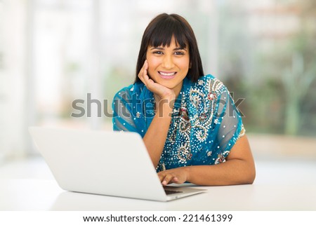 pretty indian woman using laptop at home