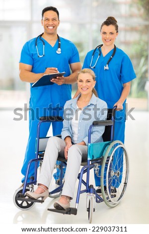 two professional health care workers and disabled patient