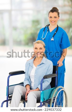 beautiful young nurse pushing middle aged patient on wheelchair