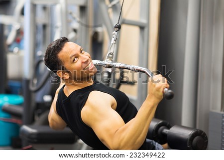 handsome mid age man doing pull-down workout in gym
