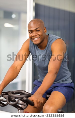 african american sitting on a stationary bike at the gym