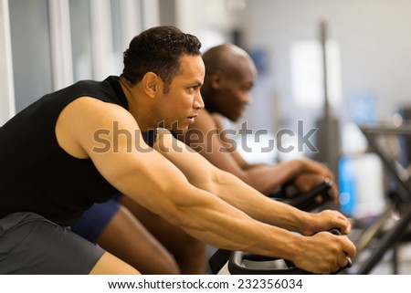 fitness men working out with stationary bike in gym