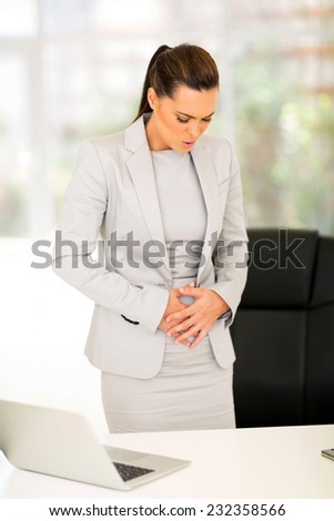 young businesswoman having period pain in office