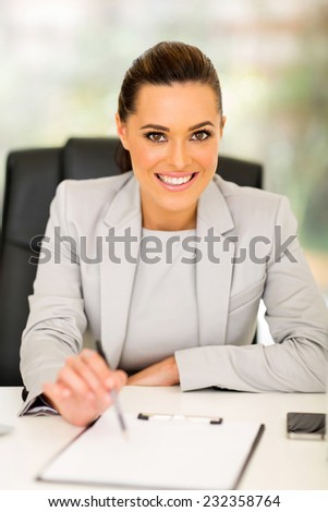 attractive businesswoman giving pen and contract to sign