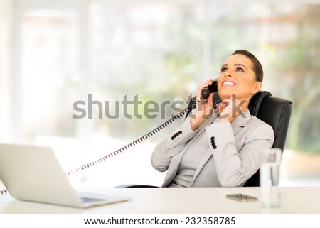relaxed businesswoman using telephone in office