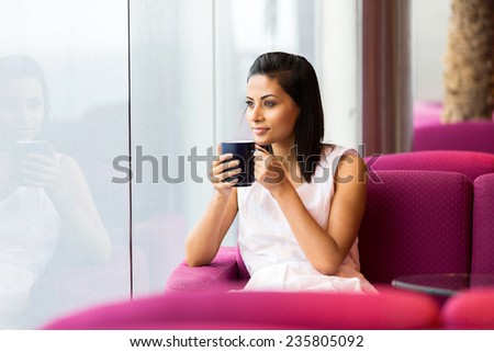 peaceful woman having cup of coffee in coffee shop