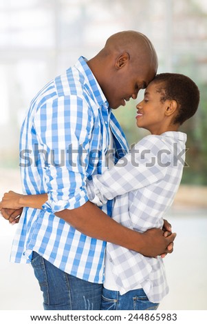passionate young african couple hugging with eyes closed