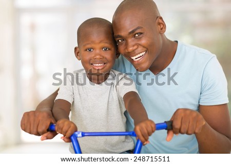 loving african american father teaching son to ride a bicycle
