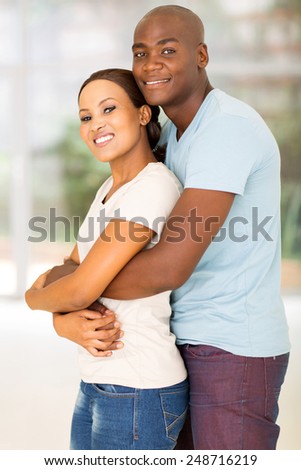 side view of handsome african man hugging girlfriend