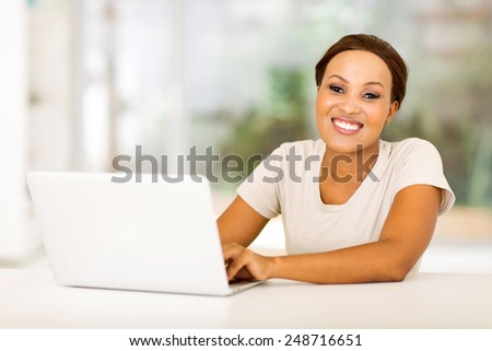 beautiful african woman with laptop computer at home