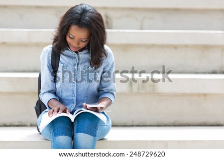pretty african american college student reading a book