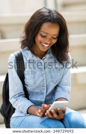 happy african university student using smart phone