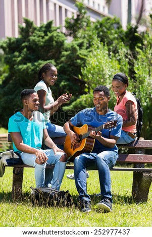 group of cheerful african american college friends having fun on campus