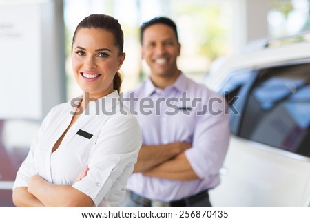 pretty young saleswoman with co-worker on background