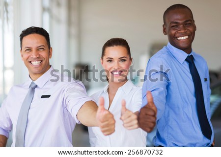 cheerful vehicle sales team giving thumbs up