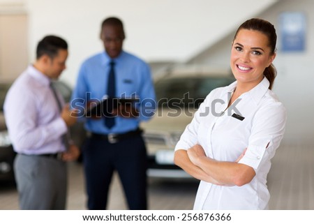 attractive female vehicle sales consultant standing in showroom