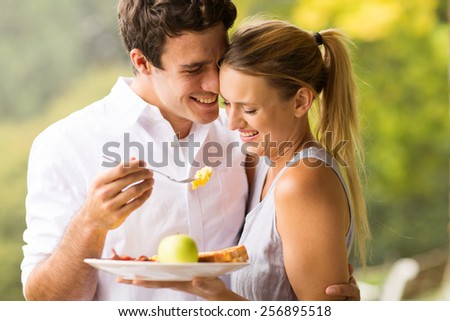 loving husband feeding wife breakfast outdoors