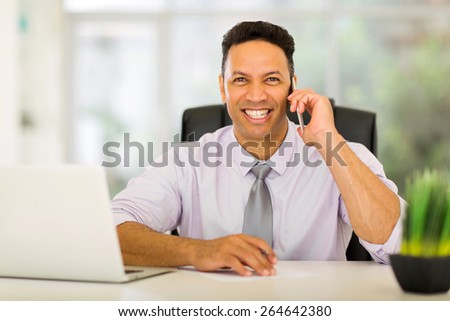 portrait of happy middle aged corporate worker talking on cell phone