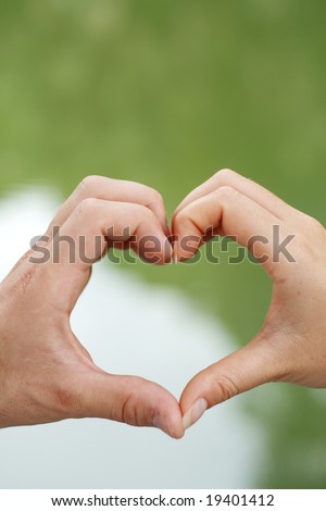 a woman and man put their hands together to make a shape of heart