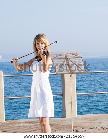 young woman play violin on beach pier