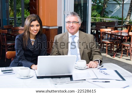 one senior business man and a young business woman meeting in coffee shop