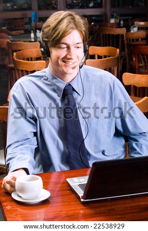 handsome young businessman talking to someone over internet communication device using headset