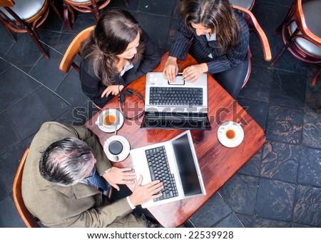 Overhead view of three business people meeting in a cafe