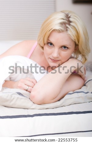 Portrait of young beautiful happy woman on bed at bedroom