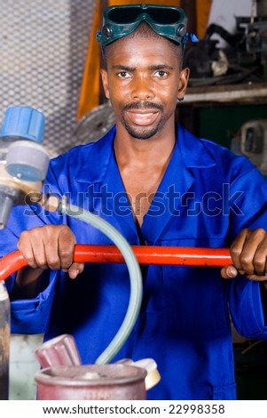 african male welder with gas bottles