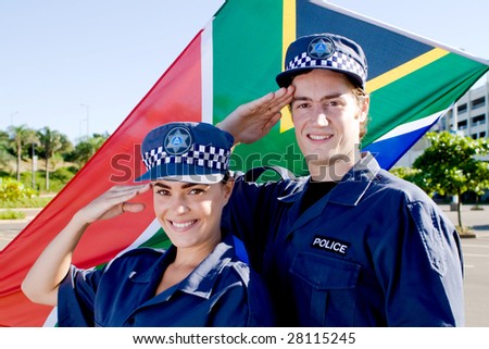 two south africa police officer saluting in front of south african flag