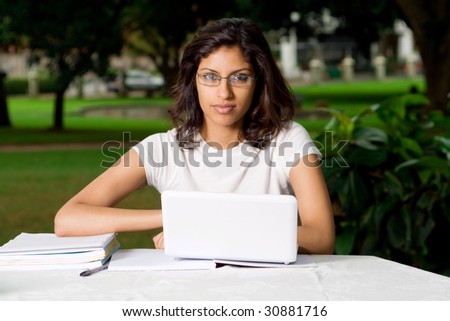 beautiful young indian college student outdoors with laptop