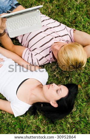 happy young college students couple lying on grass and relaxing