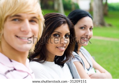 group of young college students sitting on bench