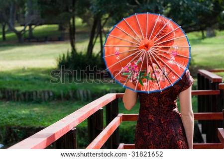 traditional woman in chinese dress and holding a umbrella