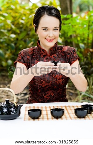 beautiful woman in chinese dress serving chinese tea