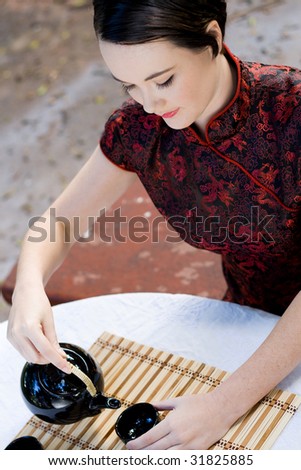 woman in chinese dress making chinese tea