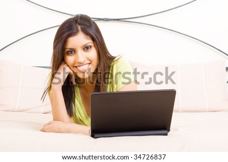 beautiful young woman with notebook computer on bed